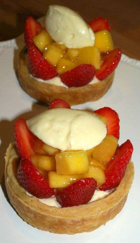 Two Pastries Topped With Fruit On Top Of A White Plate