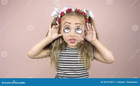 A Little Girl With Make Up On Her Face Depicts Puppet Grimaces