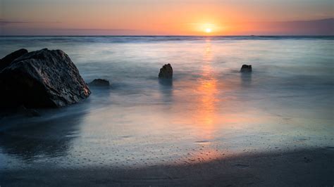Landscape Photography Of Ocean With Stone Formations During Golden Hour