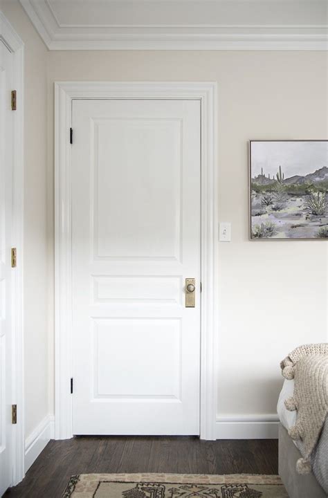 A White Door In A Room With A Rug On The Floor And Pictures Above It