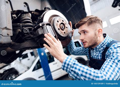 A Young Man Works At A Service Station The Mechanic Is Engaged In