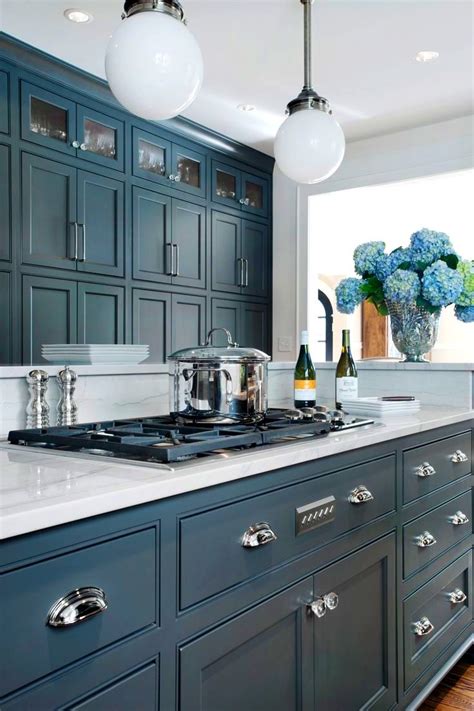 White and gray cottage kitchen designed with basket chandeliers above a blue kitchen island finished with quartz counters and backless rattan counter stools. Image result for blue grey cottage kitchen cabinets ...