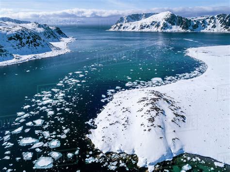 Scenic View Of Arctic Ocean With Pack Ice With Mountains On Coastline