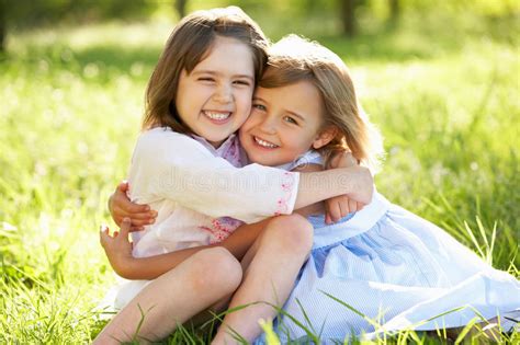 Two Young Girls Hugging In Summer Field Stock Photo