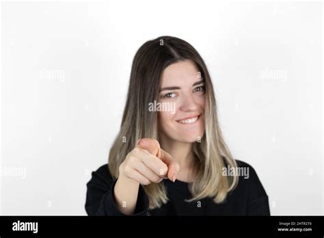 Positive Cheerful Young Woman Smiling Pointing At Camera With Index