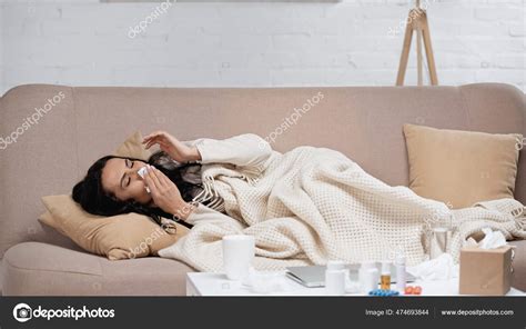 Sick Young Woman Lying Sofa Blanket Sneezing Tissue Living Room