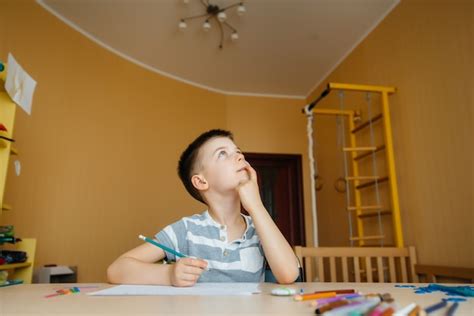 Un Niño En Edad Escolar Hace La Tarea En Casa Entrenando En La Escuela