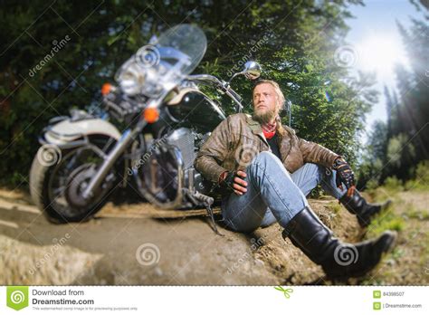 Male Biker Sitting On Dirt Road Near Motorcycle Stock Image Image Of