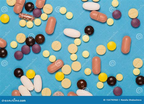 Many Scattered Colorful Medical Pills On Pastel Blue Background Stock