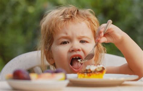 Feeding Kids Child Eating Cake In The Garden Outside In Summer Baby