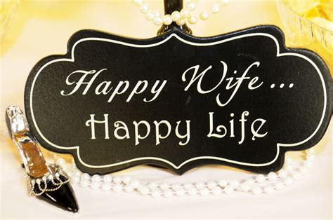 A Sign That Says Happy Wife With Pearls On The Table Next To Some Cups And Glasses
