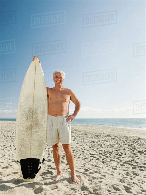 Man Holding Surfboard On Beach Stock Photo Dissolve