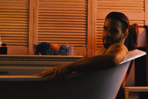 Macho Sitting Naked In Bathtub With Erotic Atmosphere Around Stock