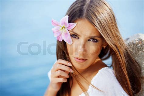 Closeup Portrait Of Beautiful Brunette Woman With Lily In Her Hair