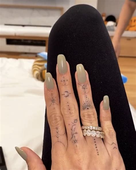 A Woman S Hand With Tattoos On It And Her Nails In The Shape Of Stars
