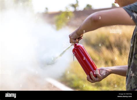 Person With Fire Extinguishing Spraying A Man Practises How To Use A Auto Fire Extinguisher In