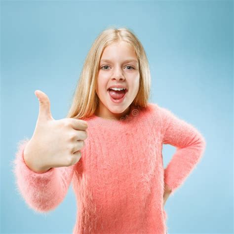 The Happy Teen Girl Standing And Smiling Against Blue Background Stock