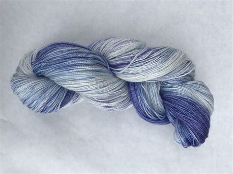 A Skein Of Blue And White Yarn Sitting On Top Of Snow Covered Ground