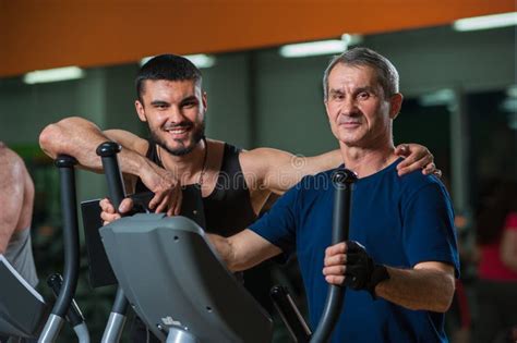 Senior Man Working With Personal Trainer In Gym Stock Photo Image Of