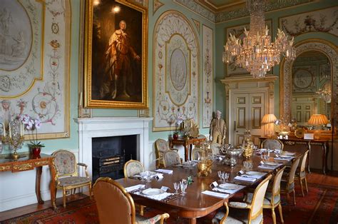 The Dining Room Is Decorated In Gold And White With Ornate Paintings On