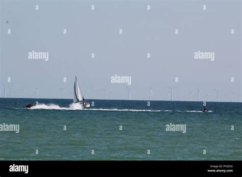 Sail Boat And Jet Skis With Offshore Wind Farm In The English Channel