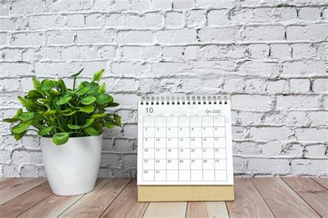 October 2022 White Calendar With Potted Plant On Wooden Desk Stock