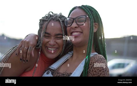 Two Hispanic Black Women Embrace South American Brazilian Sisters Hugging Posing Outdoors