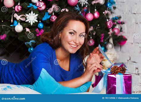 Happy Young Brunette Woman Opening T Box Near Christmas Tree Stock