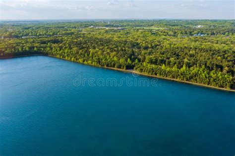 Scenic View Of A Green Forest Between Turquoise Color Lake Water Stock