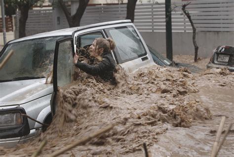 A Woman Stuck In Her Car Reacts As Flood Waters Gush Past Her During Heavy Rain In Chalandri