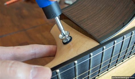 Tightening The Strap Button Screws On An Acoustic Guitar Luthier