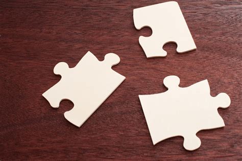 Free Stock Photo 12737 Three Blank Puzzle Pieces Over Brown Table
