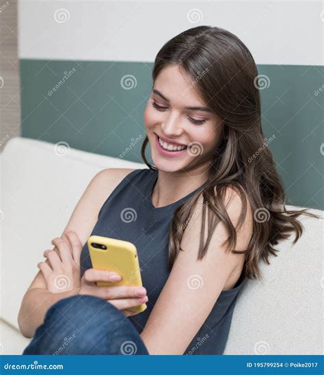 Young Beautiful Laughing Woman Using Smart Phone At Home Smiling Girl Texting On Her Phone