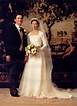a bride and groom standing in front of a painting