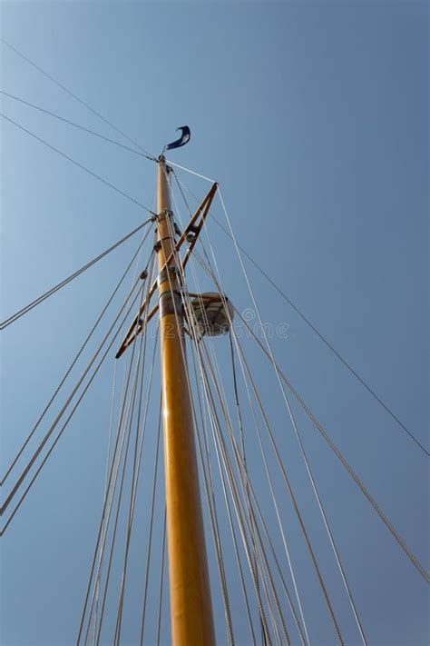 Single Ships Mast With Rigging Navigation Equipment Against A Clear