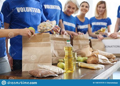 Team Of Volunteers Collecting Food Donations At Table Stock Photo