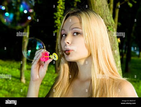 Face Of Blonde Young Woman Blowing Soap Bubbles In Summer Day Stock