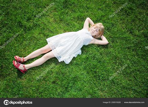 젊은 여 자가 잔디에 누워 스톡 사진 BoValentino
