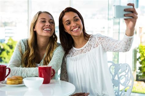 Premium Photo Two Girls Take A Selfie While Eating And Drinking Tea