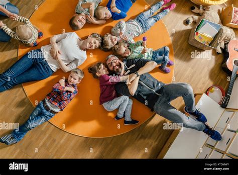 Children And Teachers Lying On Carpet In Kindergarten Stock Photo Alamy