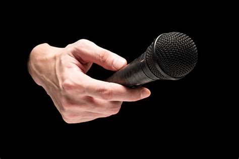 Male Hand Holding Microphone On A Black Background Stock Photo