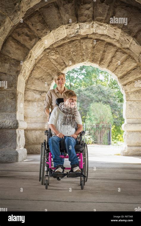 Mother Pushing Paraplegic Daughter In Wheelchair Stock Photo Alamy