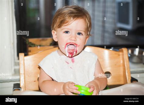 Happy Messy Baby With Food On Her Face After Eating Dessert Stock Photo