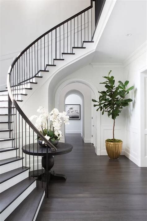 Curved Staircase Wall With Black Round Table Transitional Entrance