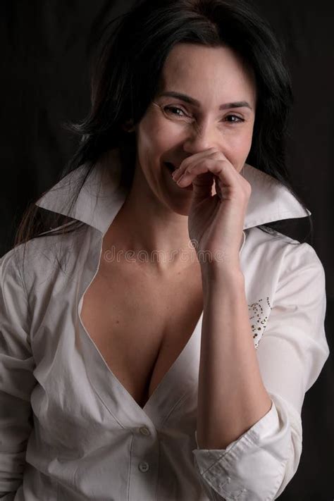 Portrait Of Beautiful Mature Brunette Woman Dressed In White Shirt Isolated On Black Background