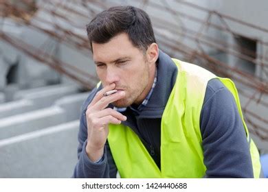 Builder Smoking Cigarette On Construction Site Stock Photo