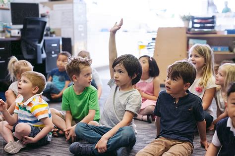 Kindergarten Kid Raising Hand In Classroom By Stocksy Contributor