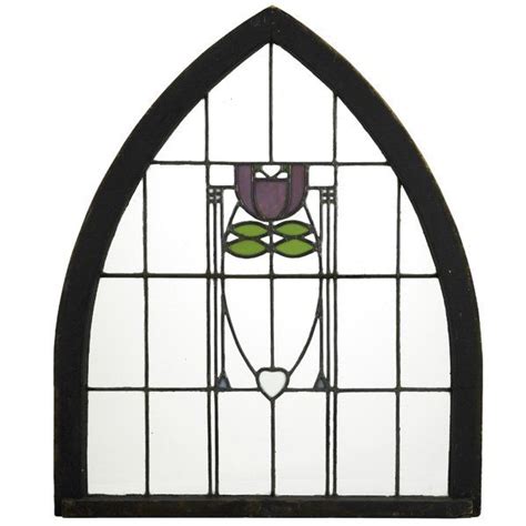 A Stained Glass Window With A Flower On It S Side And An Iron Frame