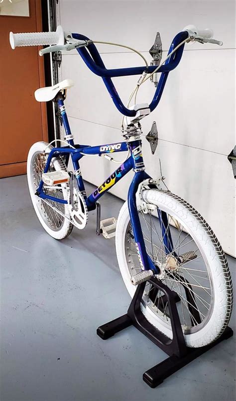 A Blue And White Bicycle Parked In Front Of A Wall With A Bike Rack On It