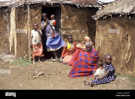 Kenya Masai Women And Children Outside Dung Covered Huts In Masai Mara